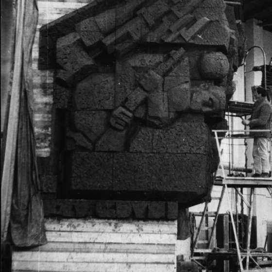 Fragment modelu pomnika w pracowni - rzeźba z dolnej części, na rusztowaniu widoczne dwie osoby przy pracy - nieznane; 1964-1966; I/A/3/55
