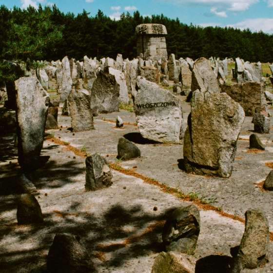 Widok na pole roztrzaskanych kamieni - w głębi pomnik, na pierwszym planie kamień z napisem „Włoszczowa”; Treblinka; 1961-1964; I/A/2/122