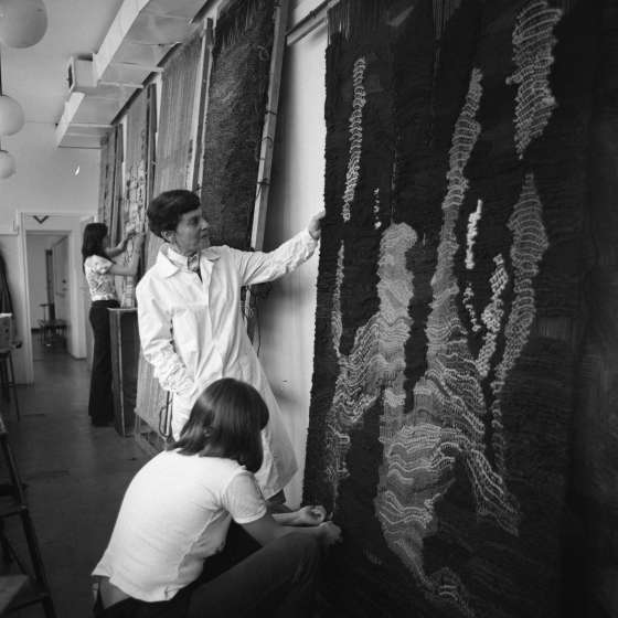 Pracownia tkaniny. Prof. Józefa Wnuk przy krosnach z tkanymi gobelinami i pracami studentów,  1980-1982 [II/193/16] 