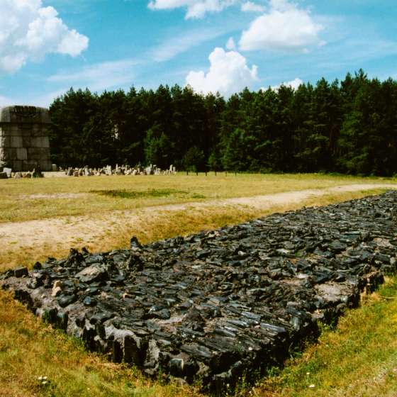 Element założenia pomnikowego - prostokąt ze stopionego czarnego bazaltu, w głębi widoczny pomnik; Treblinka; 1961-1964; I/A/2/127